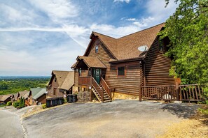 Une grande cabane en rondins comprenant plusieurs pièces, avec des fondations en pierre et une vue magnifique.