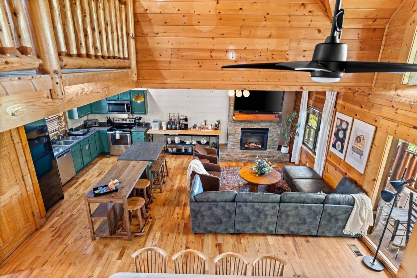 A spacious cabin interior with a dining area, kitchen, and a cozy seating area with a fireplace.