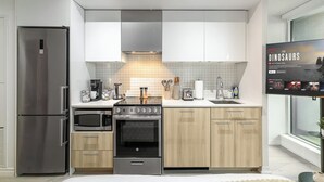 Eine moderne Küche mit Edelstahlgeräten, einem eingebauten Ofen und Holzschränken.
