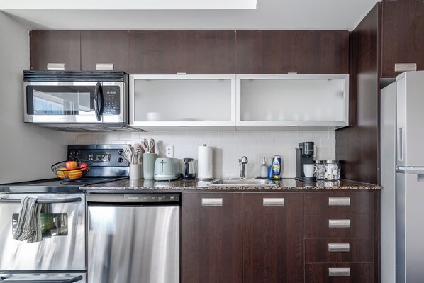 Una cocina moderna con electrodomésticos de acero inoxidable, un microondas y una cafetera.