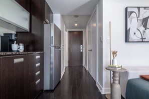 Una cocina moderna con alacenas de madera oscura, un refrigerador de acero inoxidable y una cafetera.