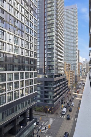 A high-rise urban building complex with multiple floors, large windows, and a busy street below.