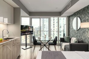 A modern apartment with a kitchen, dining area, and living room. - Downtown Studio w Balcony Steps to Eaton Centre | Parking Available (Toronto)