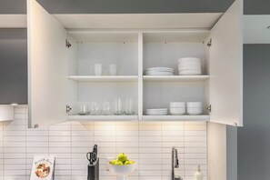 A kitchen with white cabinets, a tiled backsplash, and a bowl of green apples on the counter. - Downtown Studio w Balcony Steps to Eaton Centre | Parking Available (Toronto)