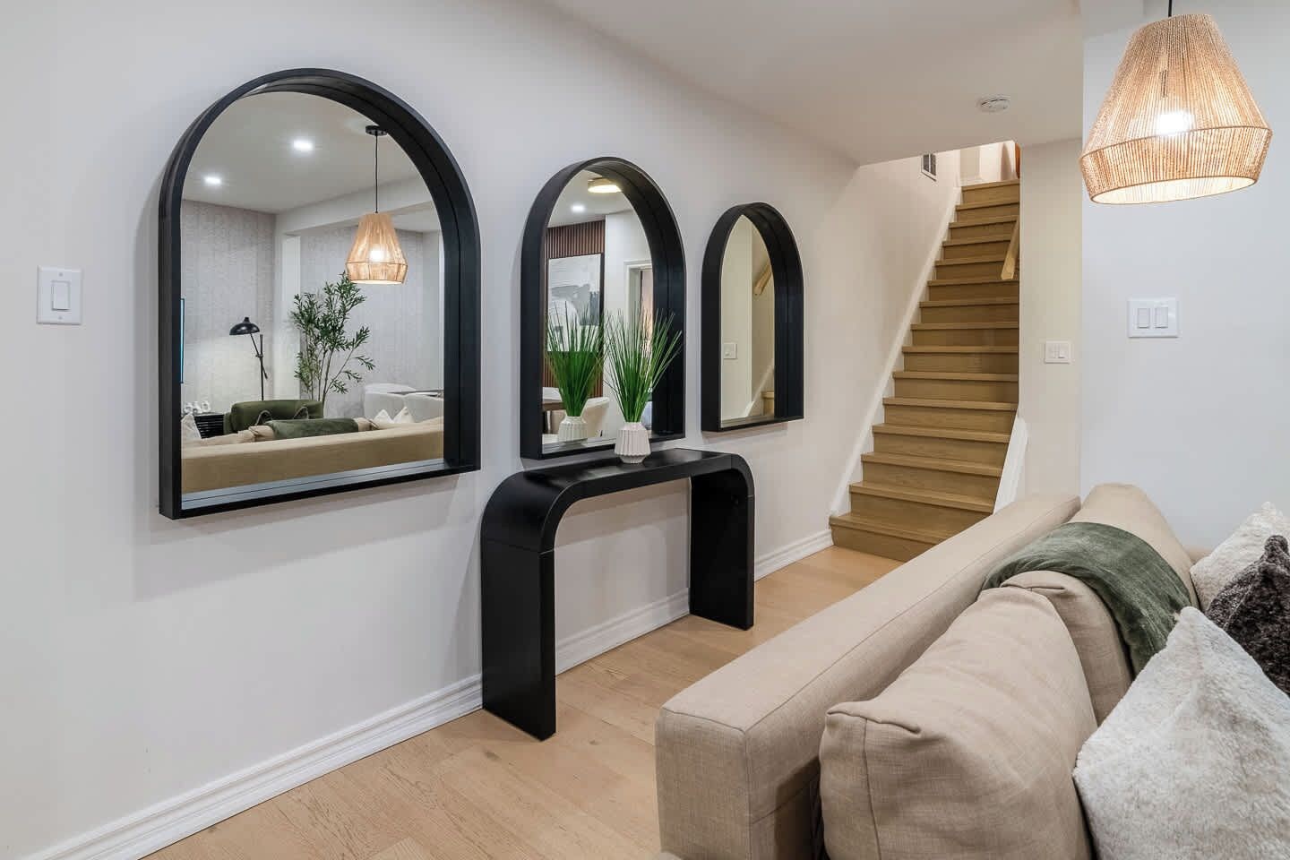 A modern interior with a staircase, a console table, and a sofa.