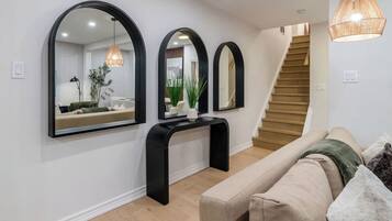 A modern interior with a staircase, a console table, and a sofa.