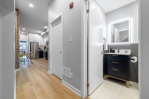 A modern kitchen with stainless steel appliances, a central island, and a view into the living area. - 3BR Downtown Toronto Stay near Chinatown & Kensington Market (Toronto)