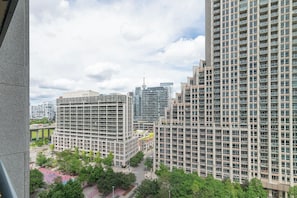 A high-rise building with a modern architectural design, featuring multiple floors with balconies. - Spacious 3BR condo with patio & free parking (Toronto)