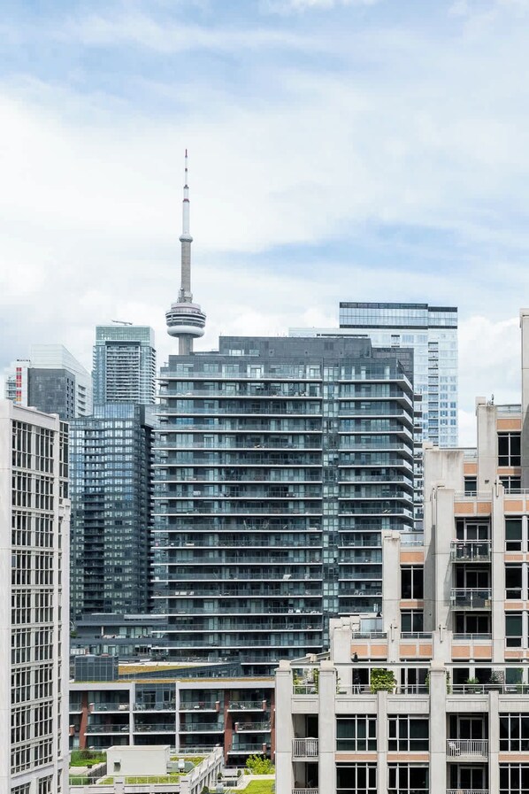 A modern high-rise building with a distinctive tower, surrounded by other contemporary structures.