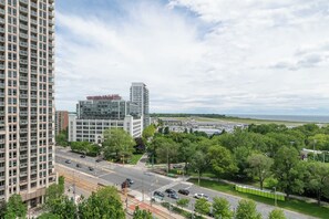 A multi-story building with a sign reading 'TIP TOP TAILORS' and a view of a highway and greenery.