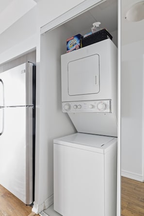 A compact kitchen with a built-in refrigerator and a microwave. - Executive Toronto Condo Balcony & City Views (Toronto)