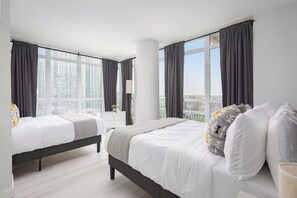 A hotel room with two beds, large windows, and a city view. - Stylish 2BR Downtown Skyline Views & Free Parking | Parking Available (Toronto)