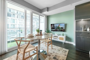 A modern kitchen with a built-in oven and a large window overlooking a cityscape. - Sunlit Studio w Balcony Views Prime Location! | Parking Available (Toronto)
