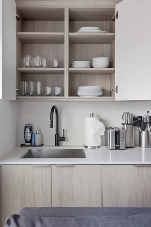 A modern kitchen with a built-in sink, a stainless steel toaster, and a set of knives in a holder.
