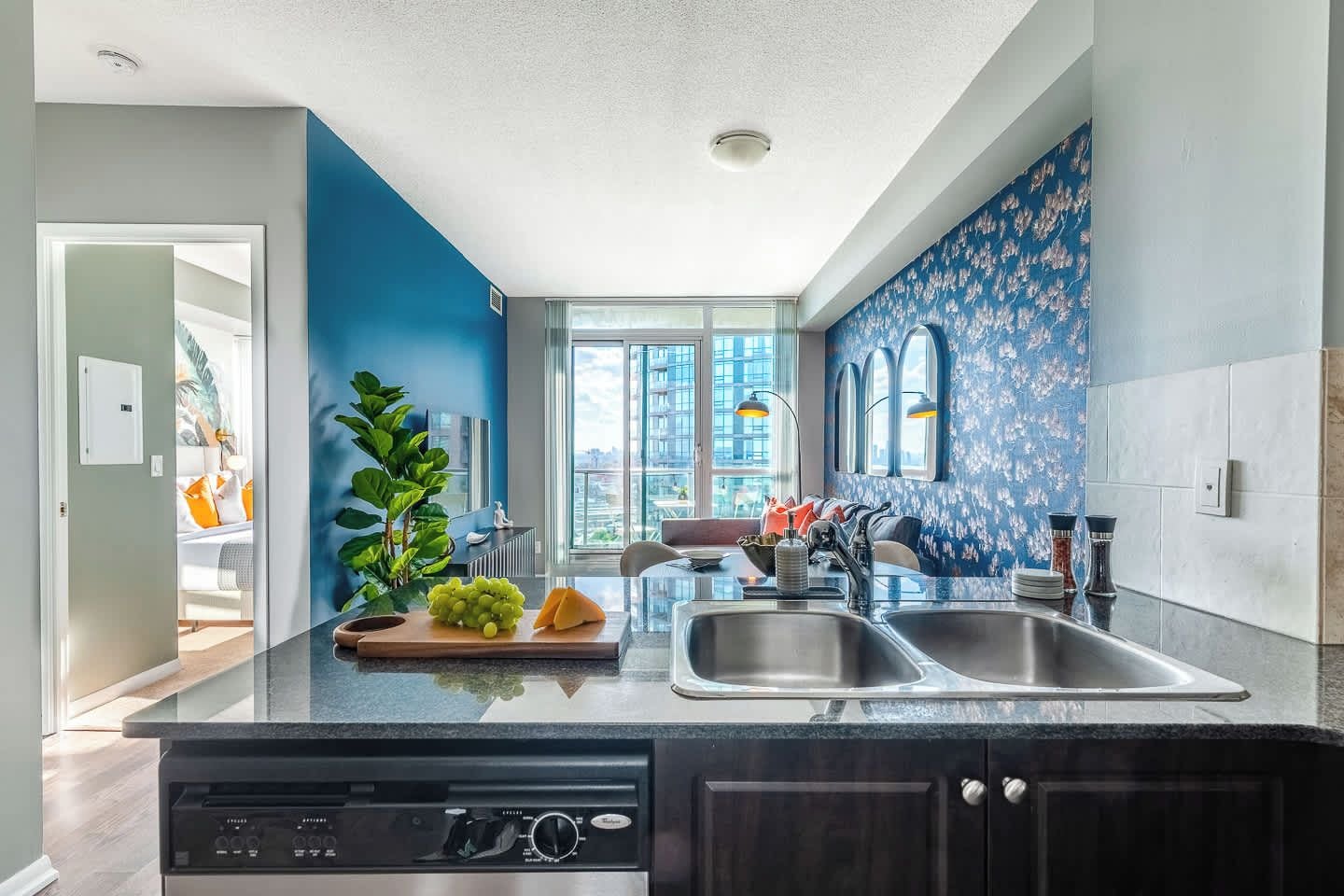 A modern kitchen with a central island, double sinks, and a view of the city.