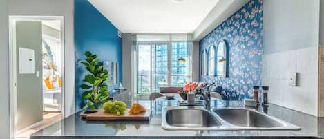 Una cocina moderna con una isla central, bacha doble y vistas a la ciudad.