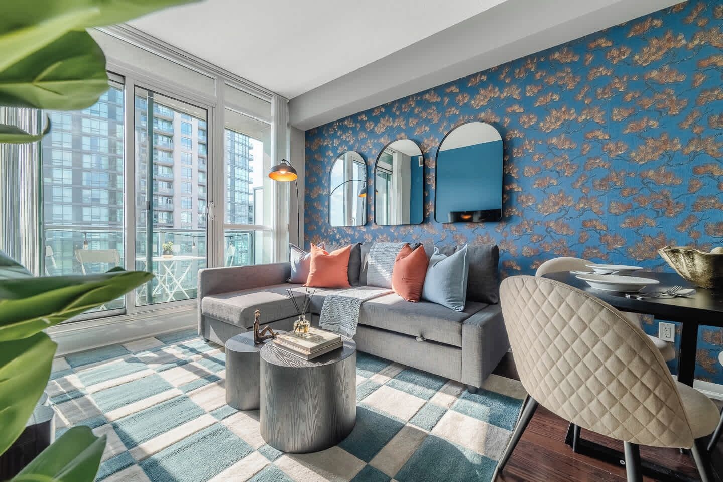 A modern living room with a grey sofa, a round coffee table, and a patterned rug.
