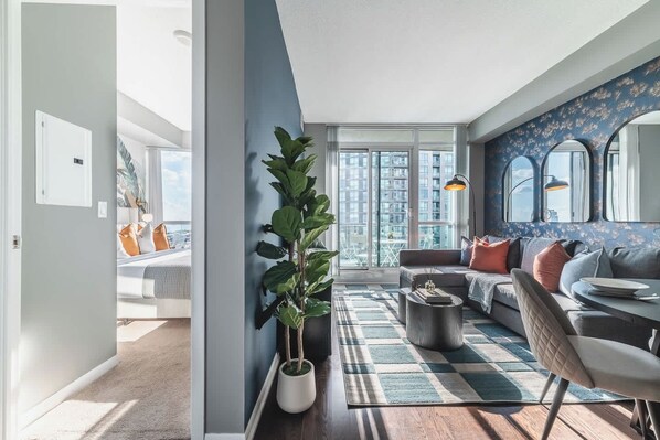 A modern living room with a sofa, coffee table, and a large window.