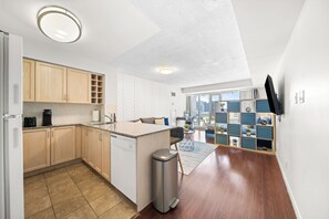 A modern kitchen with wooden cabinets, a dishwasher, and a coffee maker. - Modern Downtown Studio Steps to Yonge-Dundas | Parking Available (Toronto)