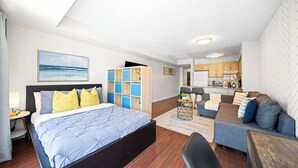 A modern bedroom with a bed, bedside table, and a view of the ocean. - Modern Downtown Studio Steps to Yonge-Dundas (Toronto)