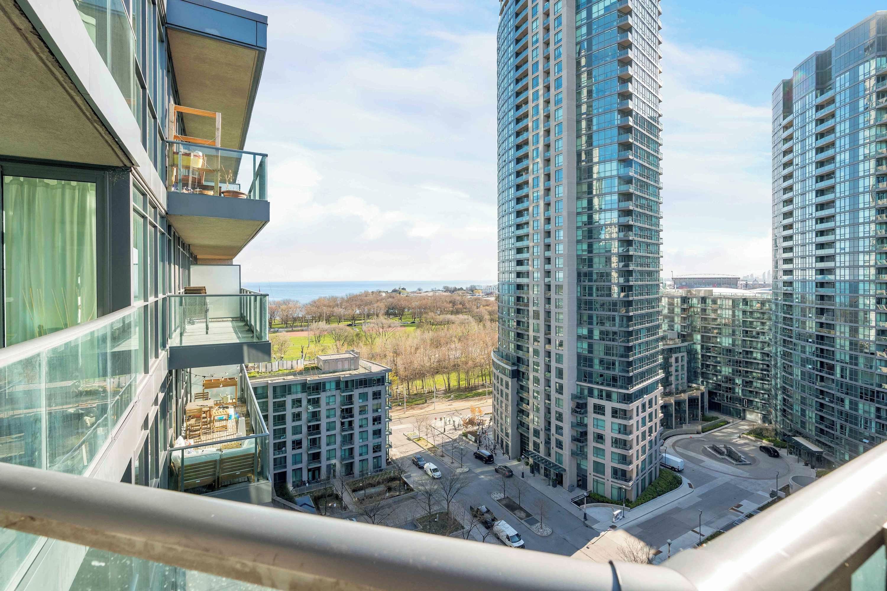 A high-rise building with multiple balconies, a view of the surrounding area, and a clear sky.
