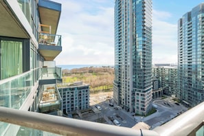A high-rise building with multiple balconies, a view of the surrounding area, and a clear sky.