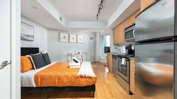 Una habitación de hotel moderna con una cama, kitchenette y baño.