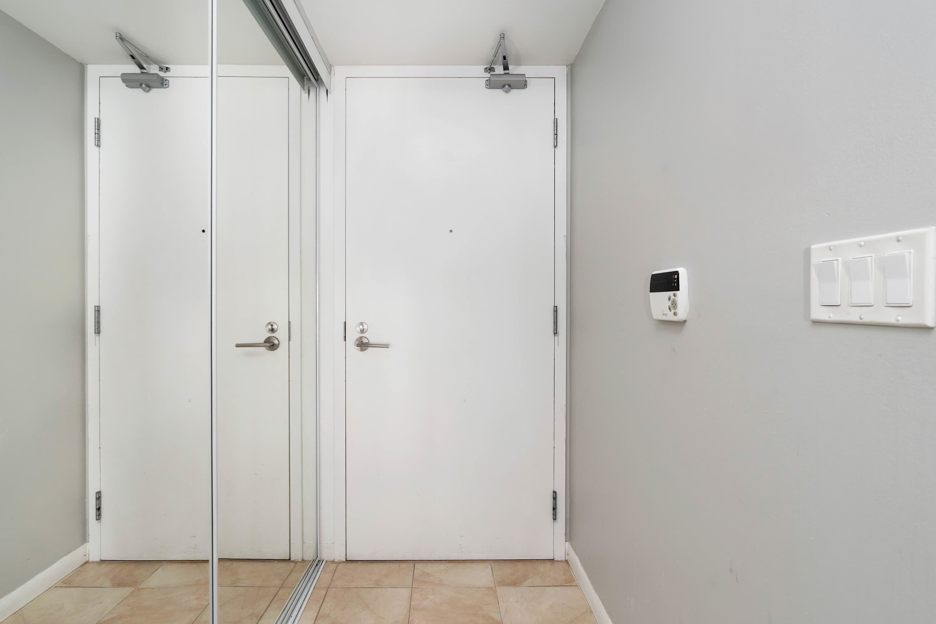 A room with a sliding door, a light switch, and a power outlet on the wall.