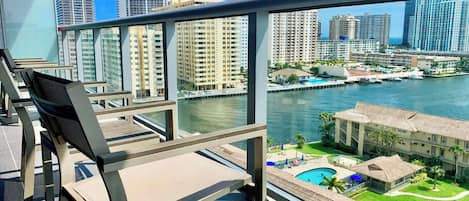 Un balcon offrant une vue sur les toits d’une ville et un port de plaisance.