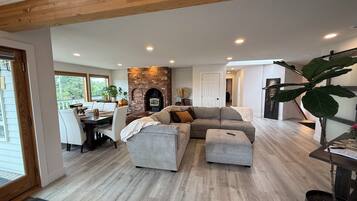 A spacious living area with a fireplace, a dining table, and a comfortable seating arrangement.