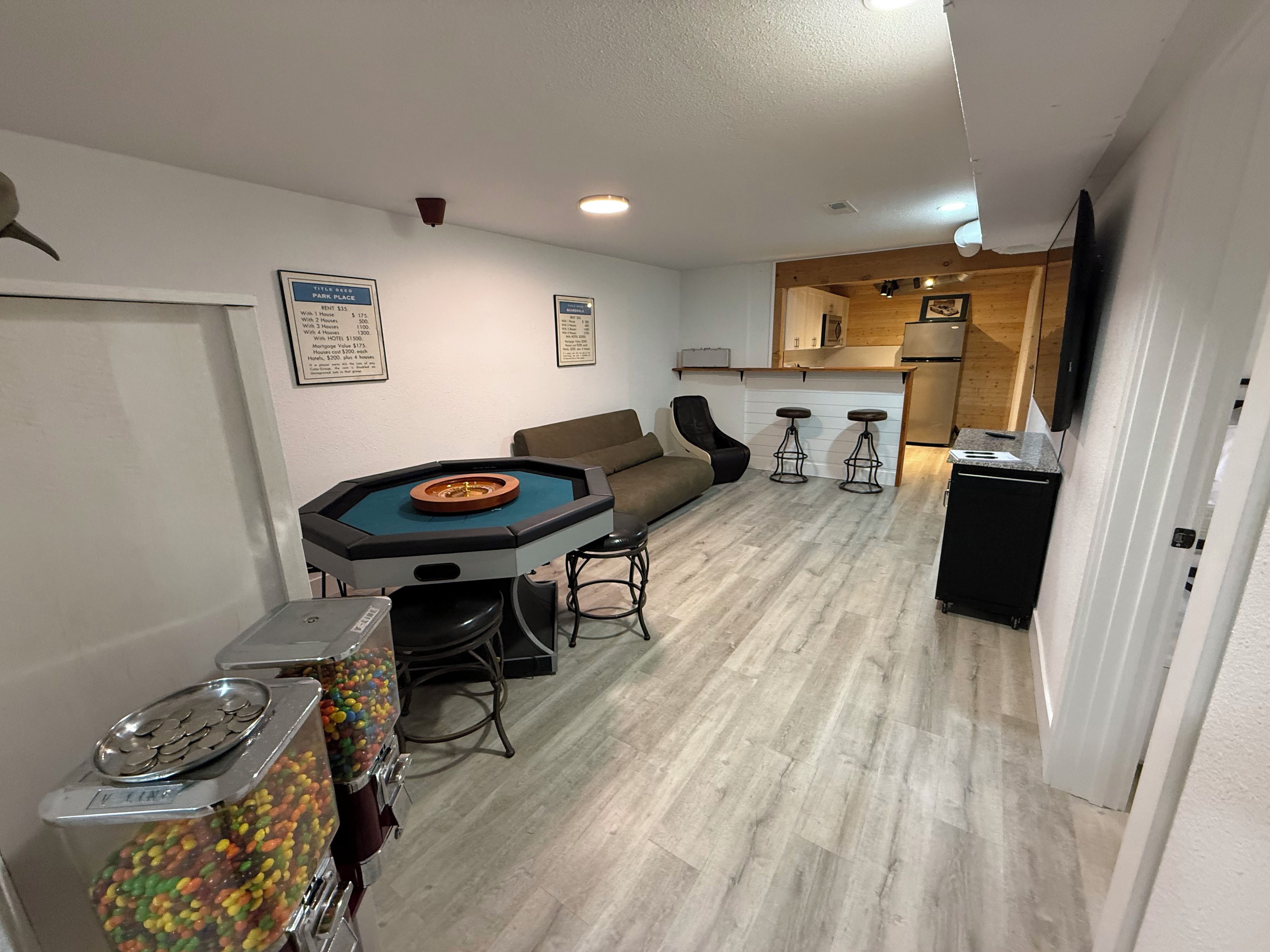 Een kamer met een pooltafel, een bank, een bar en een automaat.