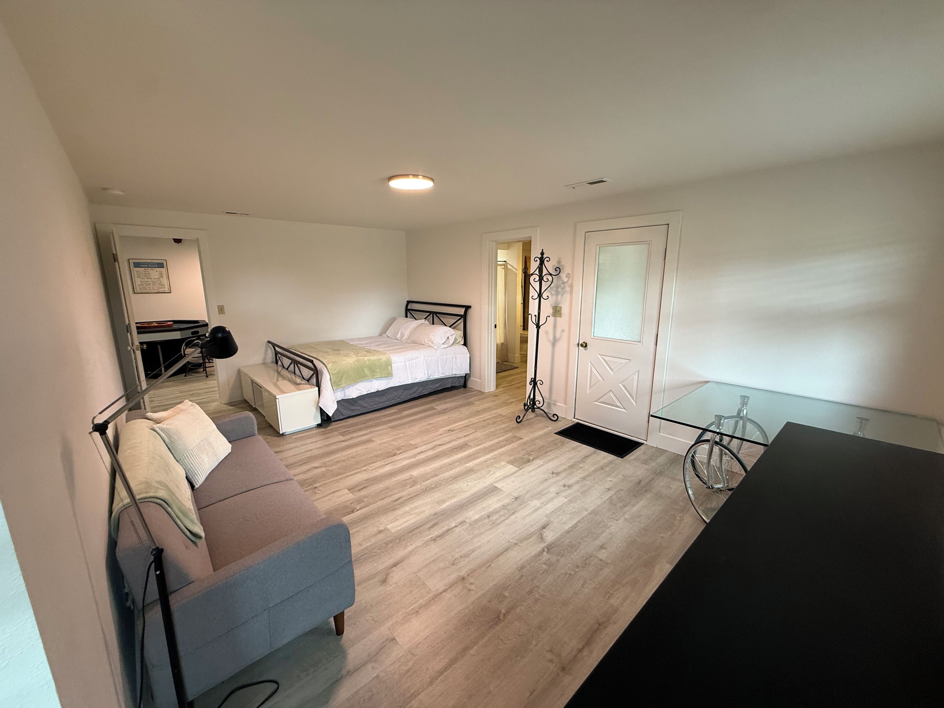 A bedroom with a bed, a desk, a chair, and a bicycle.