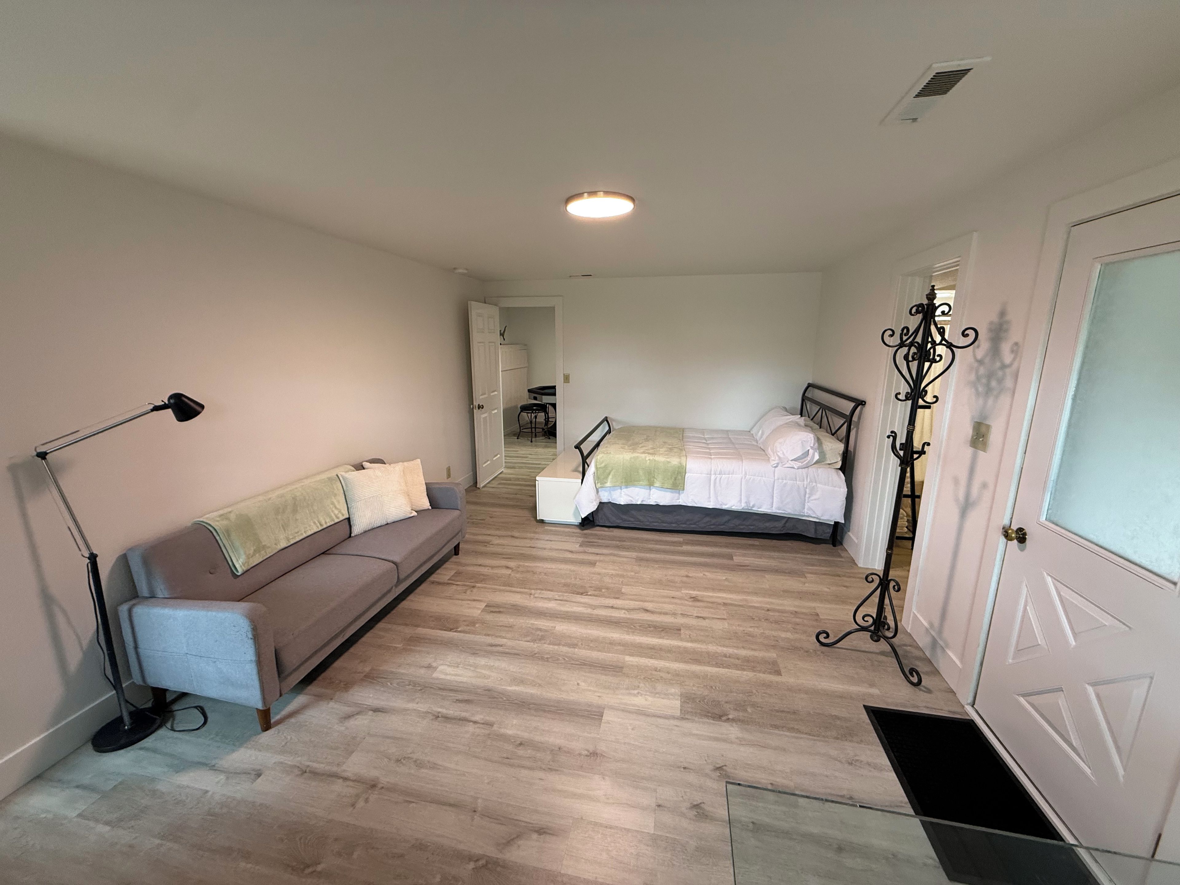 Een slaapkamer met een bed, een bank, een bureau en een stoel.