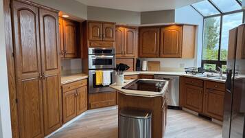 A kitchen with wooden cabinets, stainless steel appliances, and a large window.
