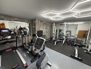 A gym with various exercise equipment, including treadmills, a stationary bike, and weight machines.