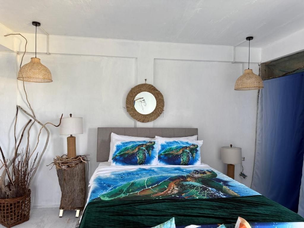 Un dormitorio con una cama, dos lámparas de pared, un espejo redondo y una planta en maceta.