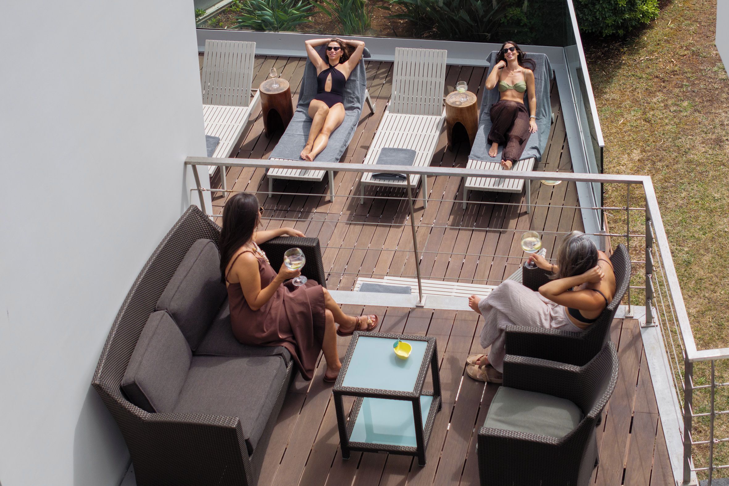A deck with outdoor seating, including a sofa and chairs, and a small table.