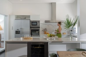 A modern kitchen with a built-in oven, a microwave, and a water dispenser.