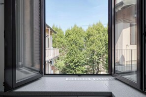 A window with a view of a balcony and trees. - w* |  Bright Apartment 1BR in the Heart of Isola (Milano)