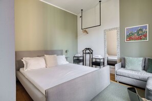 Een slaapkamer met een bed, nachtkastje, stoel, spiegel en een schilderij aan de muur.