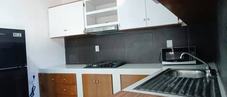 Una cocina equipada con microondas, un lavaplatos y una estufa.