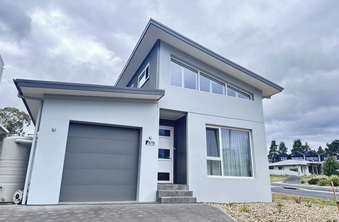 A modern two-story house with a garage, a covered entryway, and a driveway.