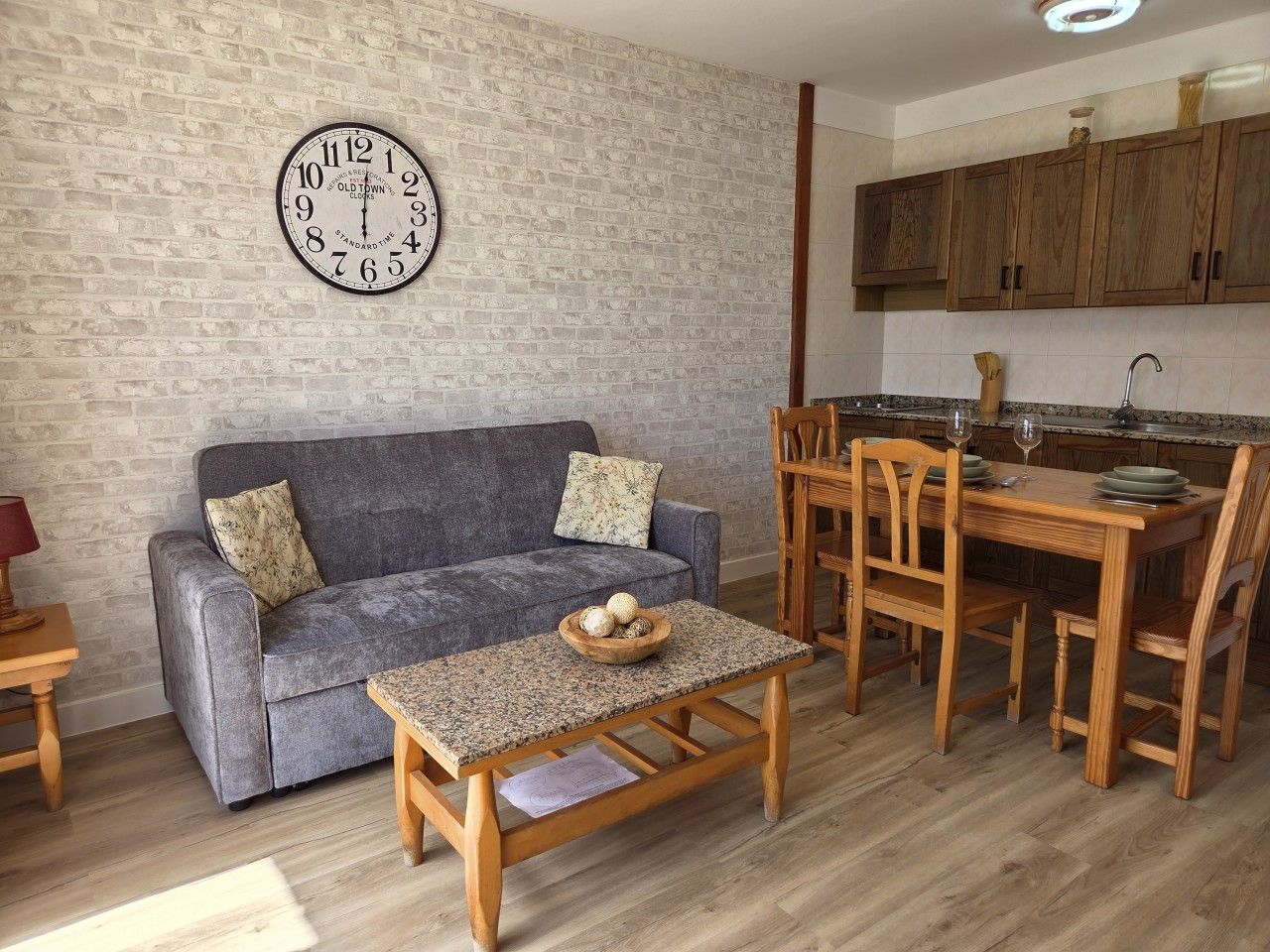 Una sala de estar con sofá, una mesa de centro y un comedor con sillas y una mesa.
