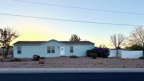A single-story house with a front door, two windows, and a small porch area. - Red Rock Retreat- Spacious Yard + RV Parking (Ivins)
