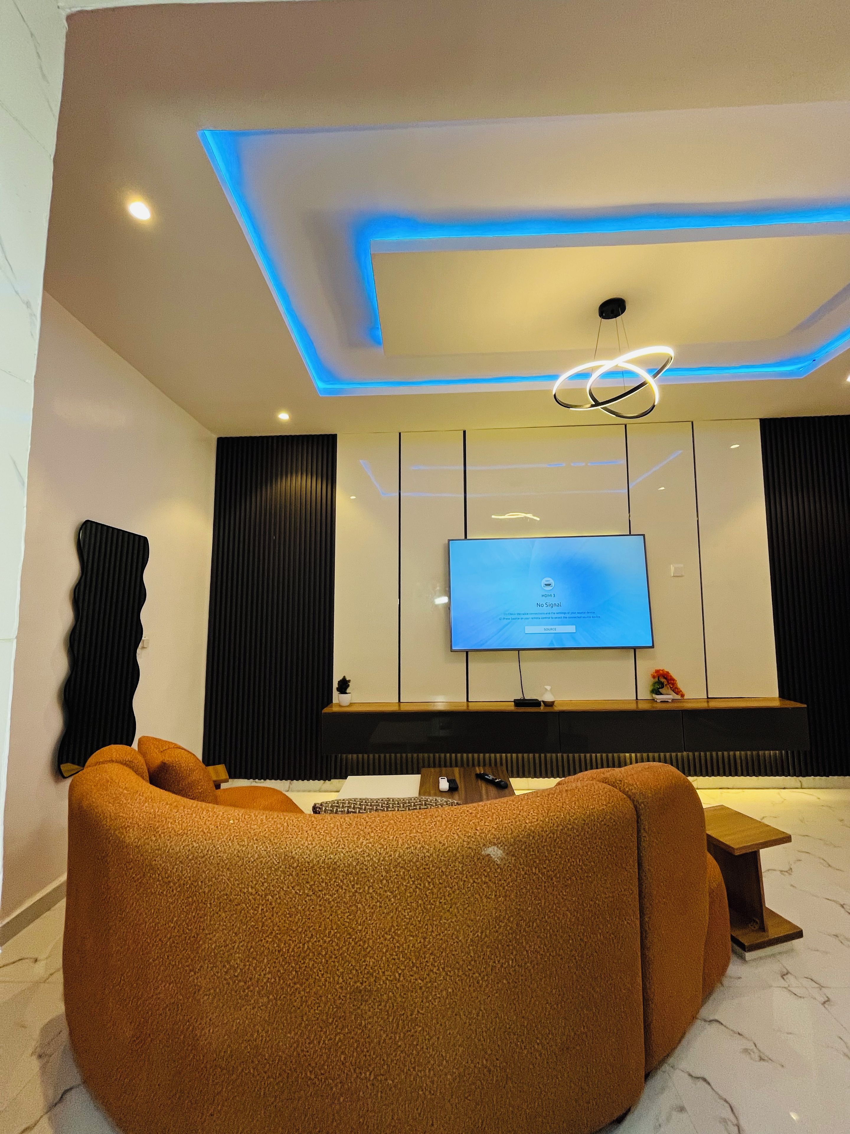 Un salon moderne avec un téléviseur à écran plat, un canapé et une table basse.