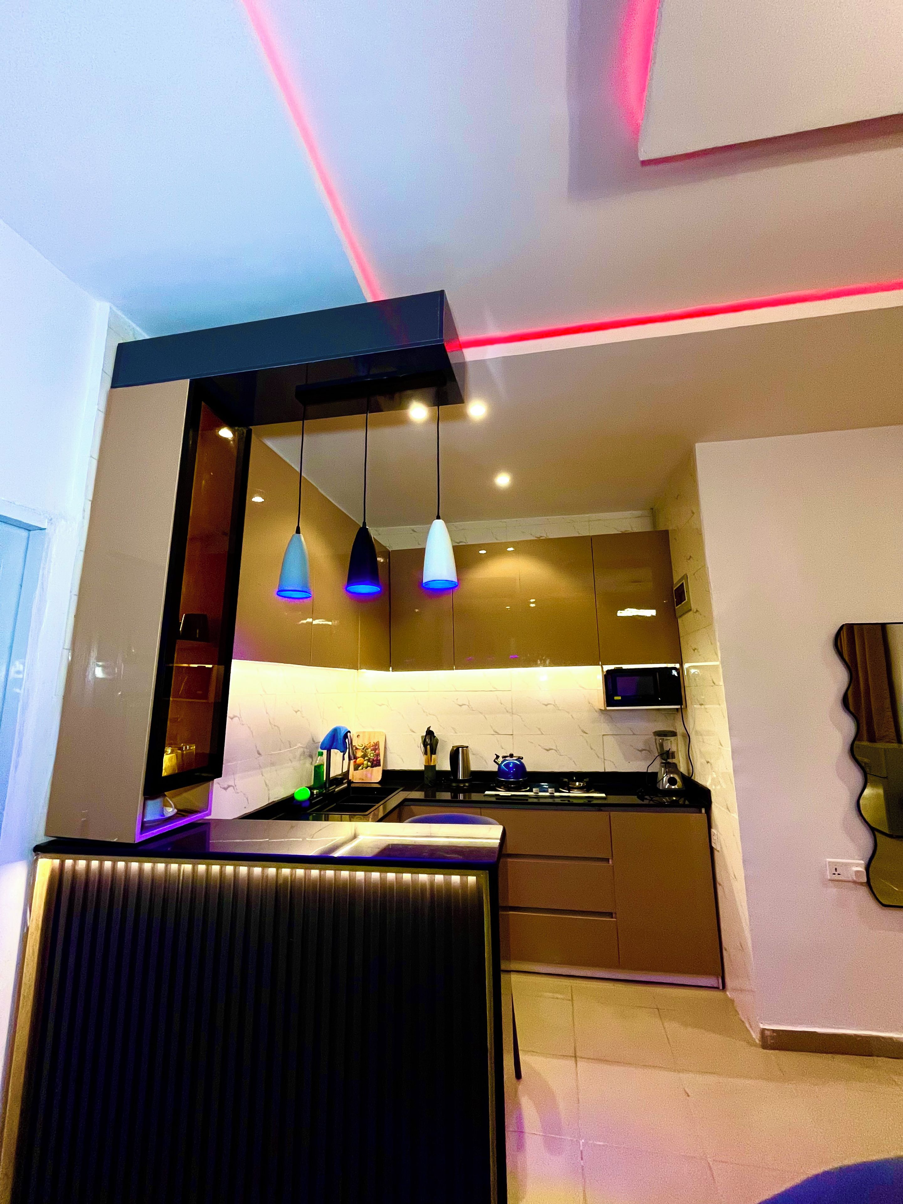Una cocina moderna con iluminación colgante, microondas y estufa.