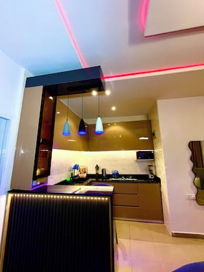 A modern kitchen with pendant lighting, a microwave, and a stove.