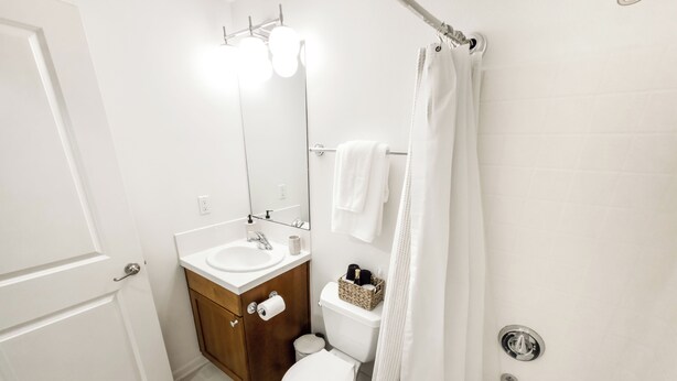 A bathroom with a white sink, mirror, toilet, and bathtub. - Eastlake Guest Suite near SLU with Private Patio (Seattle)