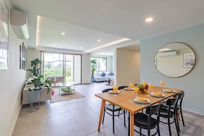 A dining area with a wooden table set for six, surrounded by black chairs. - Vrbo Property (Cuernavaca)