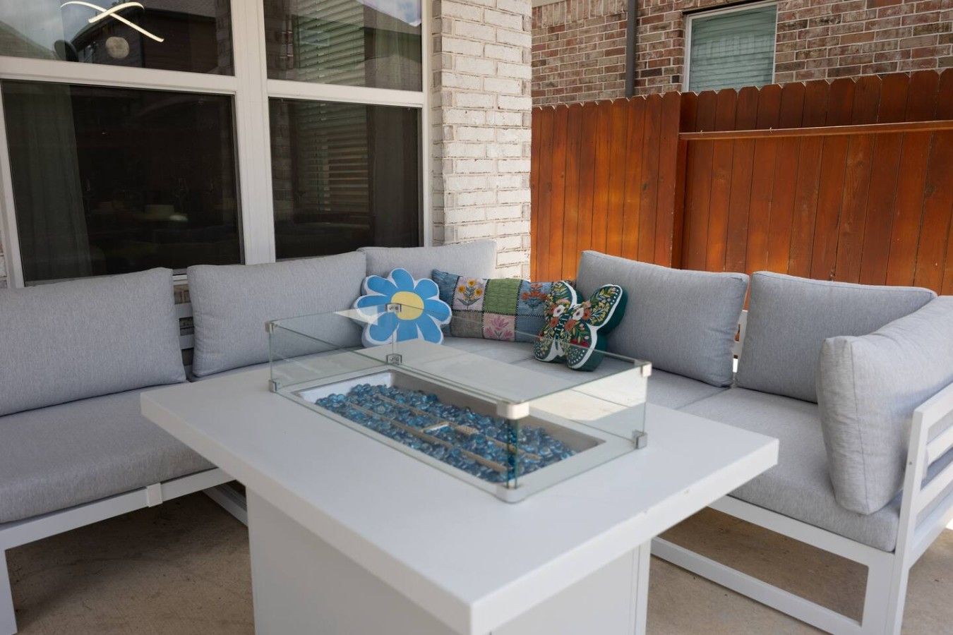 A modern outdoor seating area with a white table and blue decorative elements.